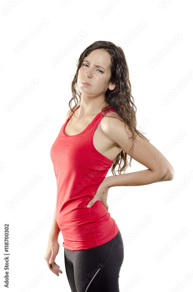 Back pain. Athletic woman in red sportswear standing with her ha Back pain. Athletic woman in red sportswear standing with her ha