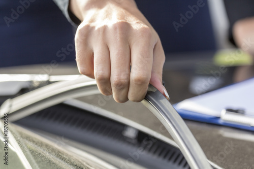 Girls hand corrects wipers on the glass of the car. 
