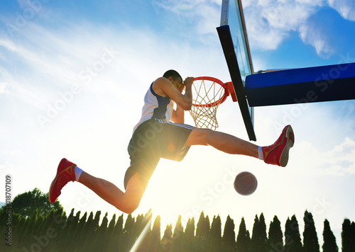 Billede på lærred Street basketball player performing power slum dunk.