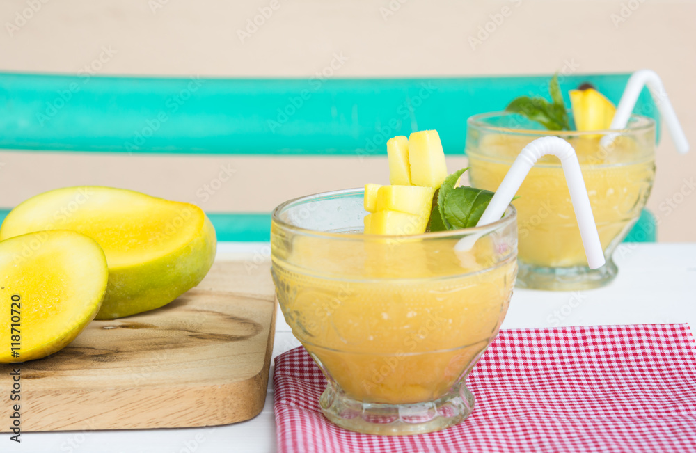 Fototapeta premium Mango juice in glass on table cloth and mango fruit,