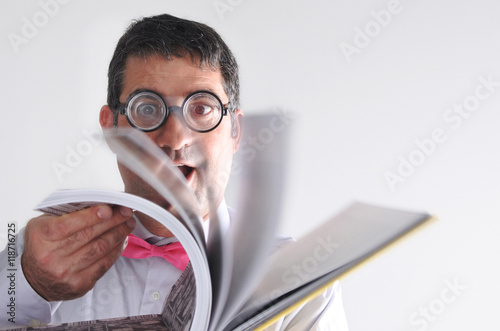Happy geeky man reads a book photo