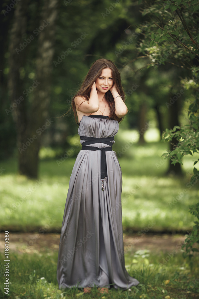 Beauty Romantic Girl Outdoors. Teenage Model with Casual Dress in park. Blowing Long Hair. Beauty Romantic Girl Outdoors. Teenage Model with Casual Dress in park. Blowing Long Hair.