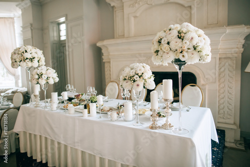 Table decor with white flowers and candles for an event party or wedding reception photo