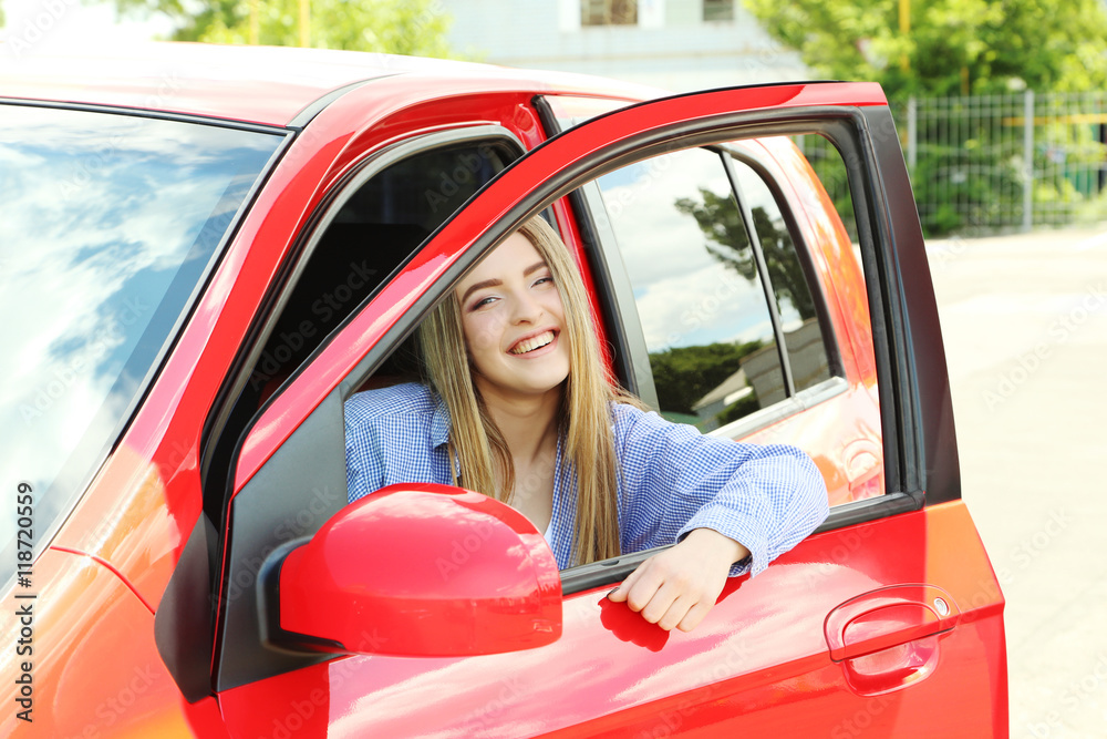 Beautiful young girl sitting in red car Beautiful young girl sitting in red car