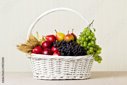 White basket with grapes, apples and pears.