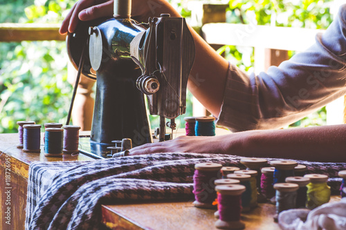 Photos Young girl sews on the old sewing machine