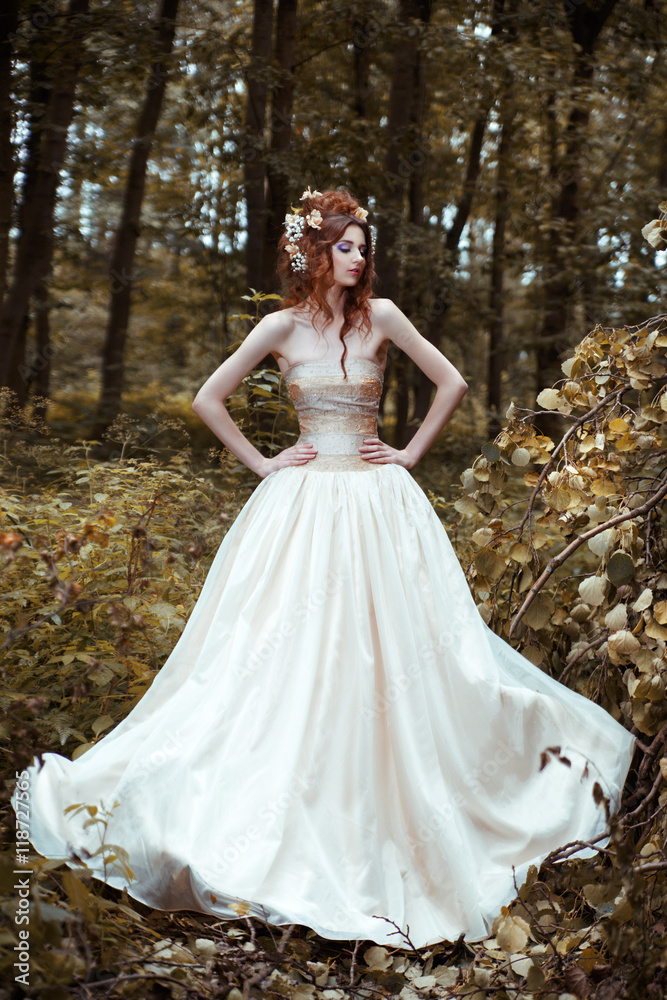 Portrait of a bride in a long flowing dress in the mysterious forest