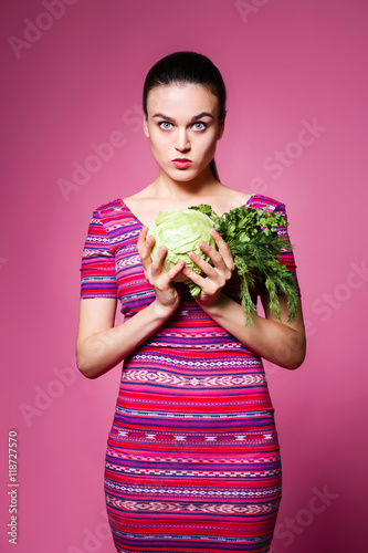 beautiful cheerful girl with cabbage and parsley in the Studio o © aemstock