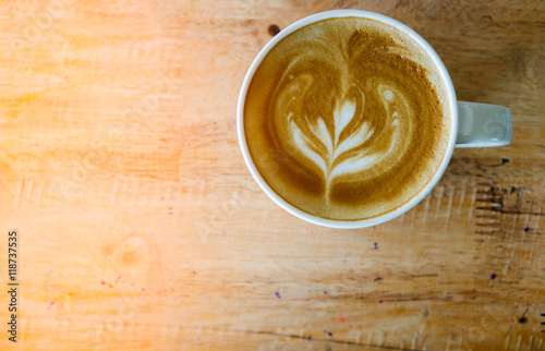 Coffee in white cup on wood table in coffee shop.