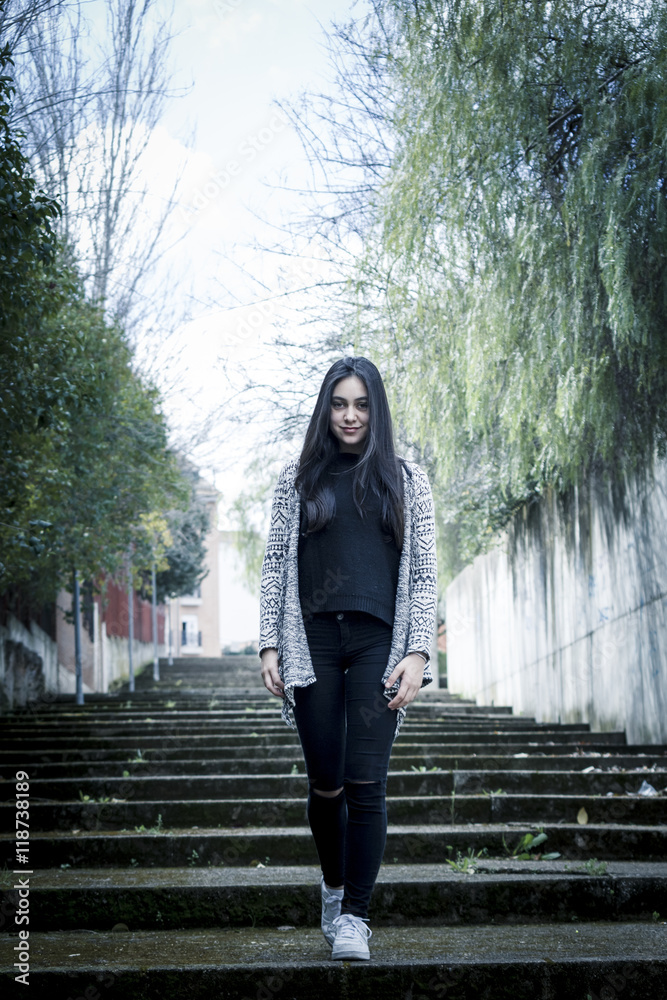 Chica joven morena subiendo y bajando feliz las escaleras en la ciudad. Modelo morena posando en las escaleras. Chica joven morena subiendo y bajando feliz las escaleras en la ciudad. Modelo morena posando en las escaleras.