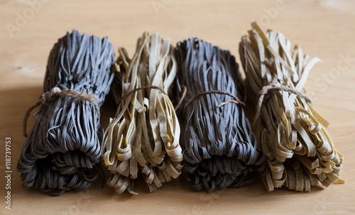 Food. black and beige pasta  not cooked  wooden background