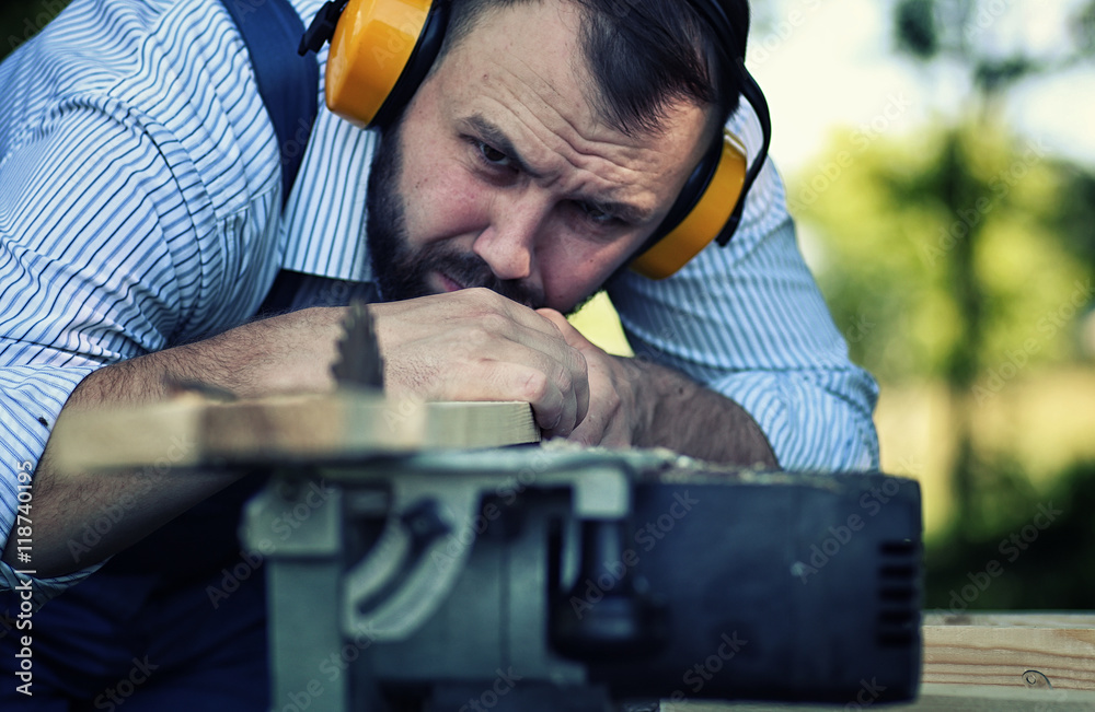 Obraz premium worker beard man with circular saw