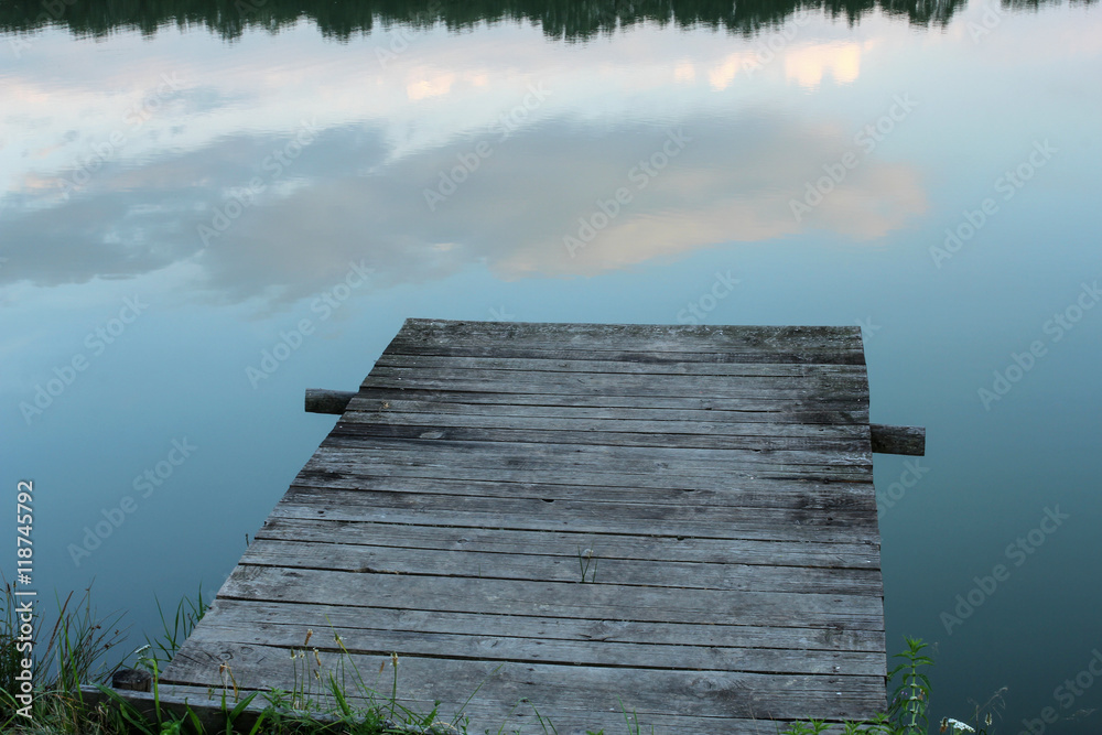 wooden pier and calm waters of the lake at dusk