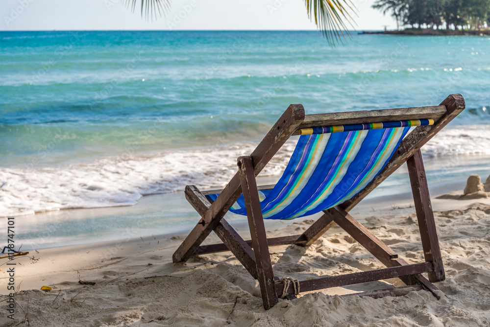 Beach chair on beautiful tropical island beach in sunny day blue sky background. Summer tropical travel holiday vacation or green nature concept. Beach chair on beautiful tropical island beach in sunny day blue sky background. Summer tropical travel holiday vacation or green nature concept.
