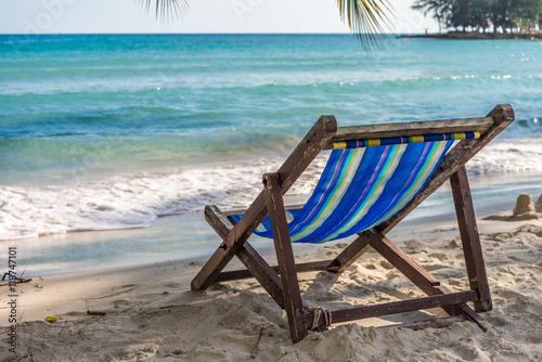 Beach chair on beautiful tropical island beach in sunny day blue sky background. Summer tropical travel holiday vacation or green nature concept.