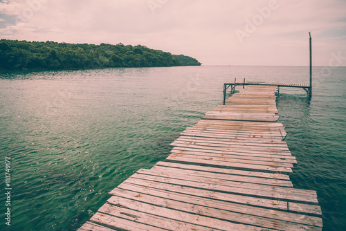 Wooden bridge on beautiful tropical island beach in sunny day blue sky background. Summer tropical travel holiday vacation or green nature concept.
