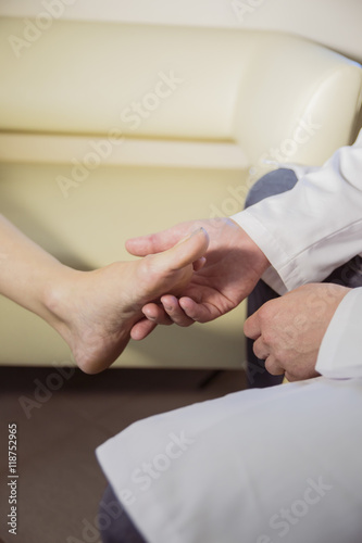 the hands of the doctor examines the foot of a patient © de Art