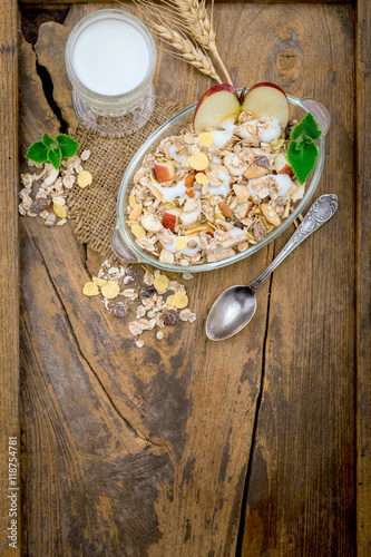 Healthy bowl of muesli, apple, fruit, nuts and milk for a nutrit photo