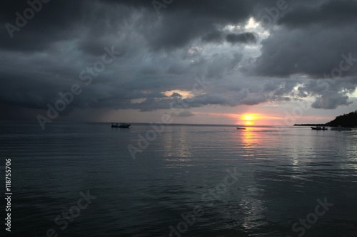 beautiful asian cloudy sunset over the ocean with boat silhouettes