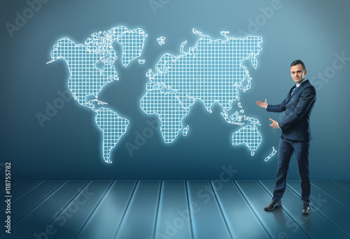 Businessman stands showing world map by both hands