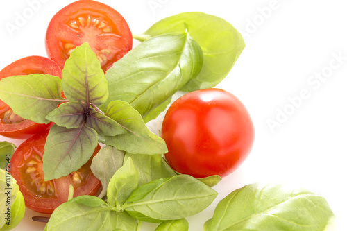 Tomatoes with basil on white background