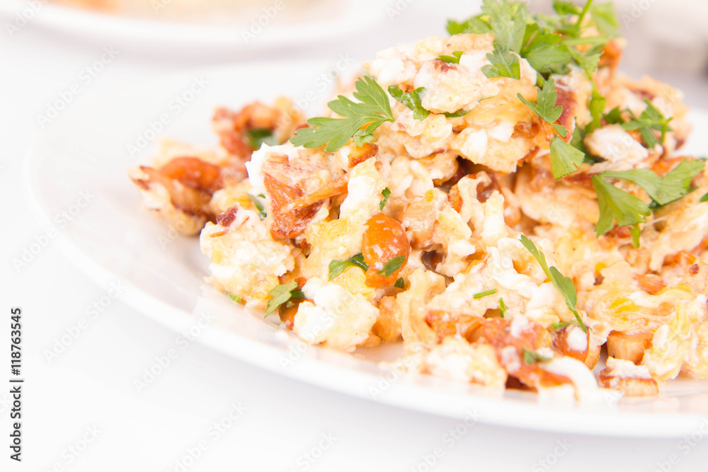 Scrambled eggs with chanterelle and parsley with some white bread on a white background Scrambled eggs with chanterelle and parsley with some white bread on a white background