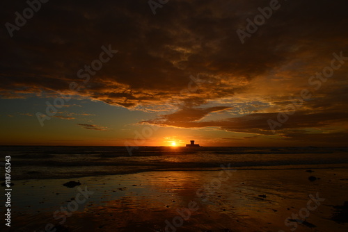 St.Ouen s Bay  Jersey  U.K.  Wide angle image of a dramatic Summer sunset near high tide.