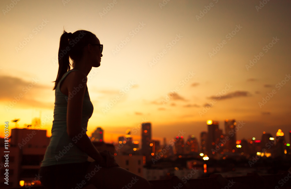 Young woman in the city watching the sunset. Young woman in the city watching the sunset.