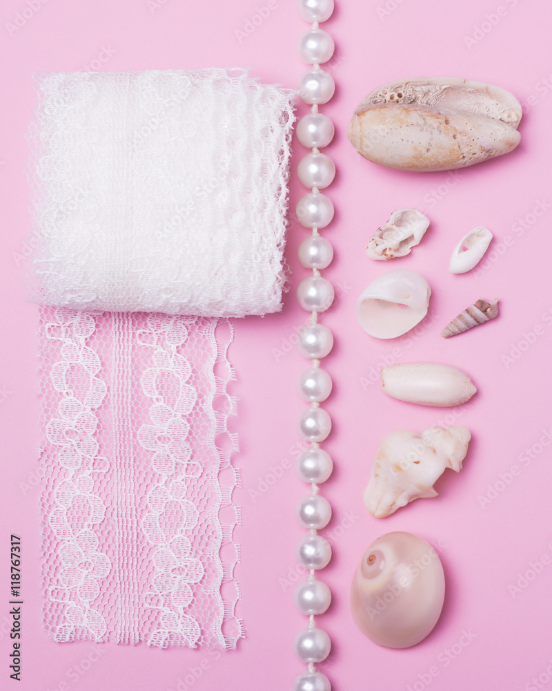 Sea shells, pearls and lace on a pink background Sea shells, pearls and lace on a pink background