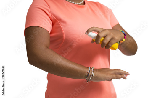 Mosquito repellent. Woman spraying insect repellents on skin