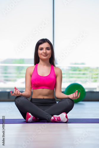 Young woman meditating in gym health concept