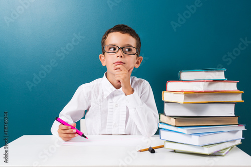 Cute little boy with books on the table