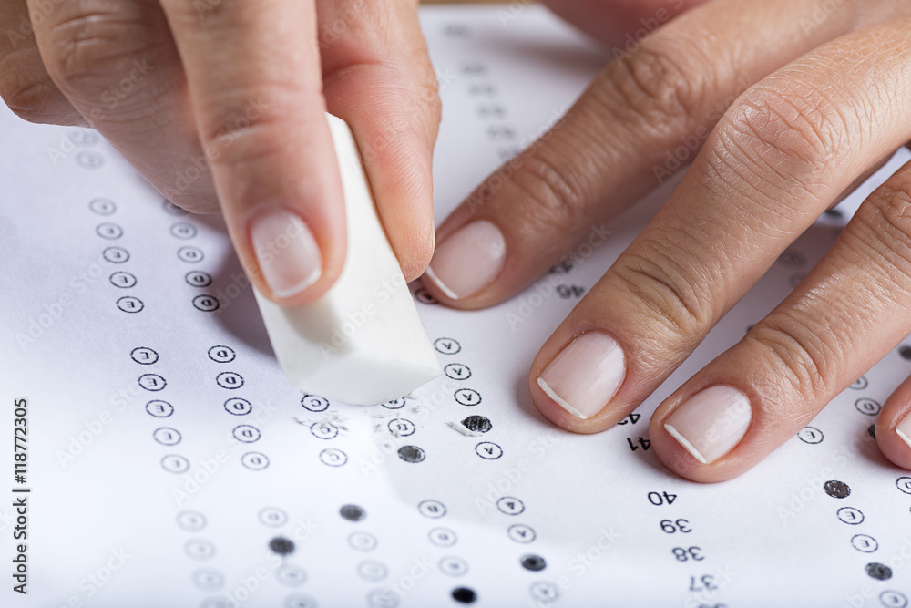 Student erasing test with pencil with eraser tip close up. Student erasing test with pencil with eraser tip close up.