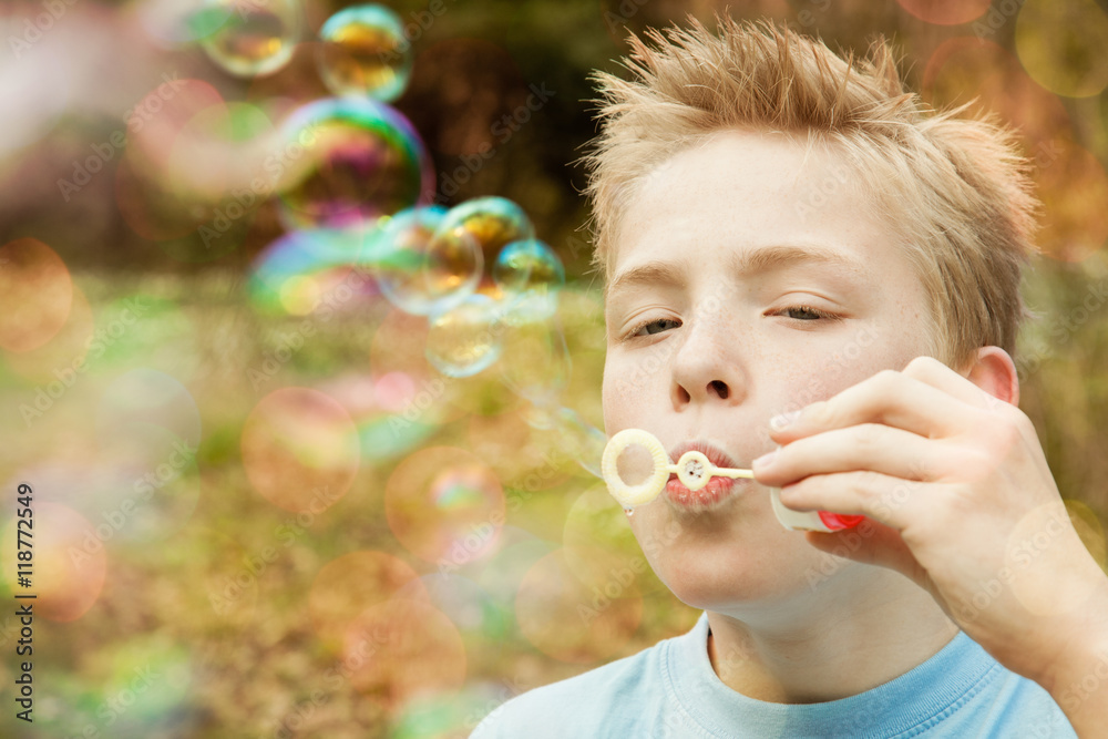 Male child blowing bubble outdoors