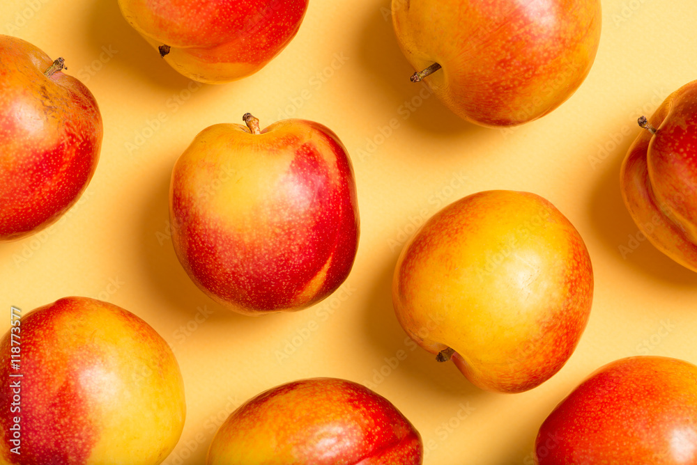 delicious, sweet, organic plums in red and yellow, isolated on a yellow craft paper background, top view, close up, horizontal delicious, sweet, organic plums in red and yellow, isolated on a yellow craft paper background, top view, close up, horizontal