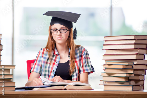 Student with stacks of books preparing for exams