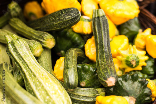 freshly harvested, delicious organic summer squashes (pattypan squash and zucchini) in a basket at farmers market in Vancouver, BC. horizontal, close up