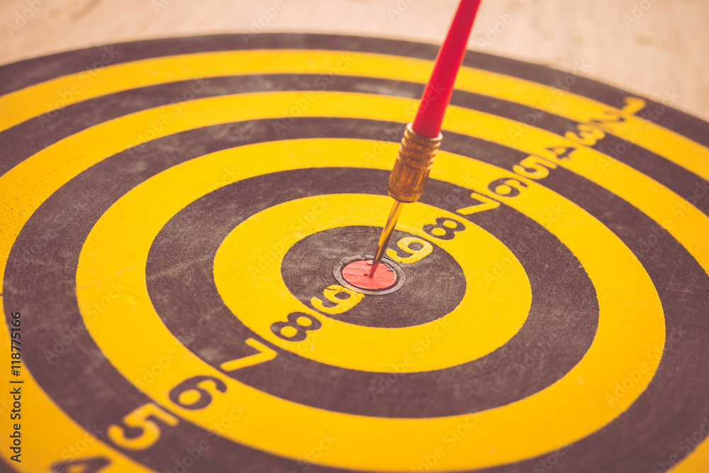 Red dart arrow put on center of dartboard - business concept success target Red dart arrow put on center of dartboard - business concept success target