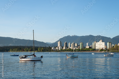 evening time in Kitsilano Dog Beach, Vancouver, British Columbia, Canada. Sailing boats are resting on the ocean while looking at the city skyline in English Bay. Sunset in English Bay.