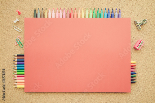 Top view of education and art supplies on cork table with empty space color paper 