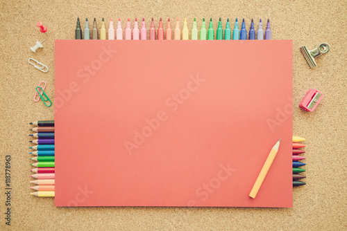 Top view of education and art supplies on cork table with empty space color paper