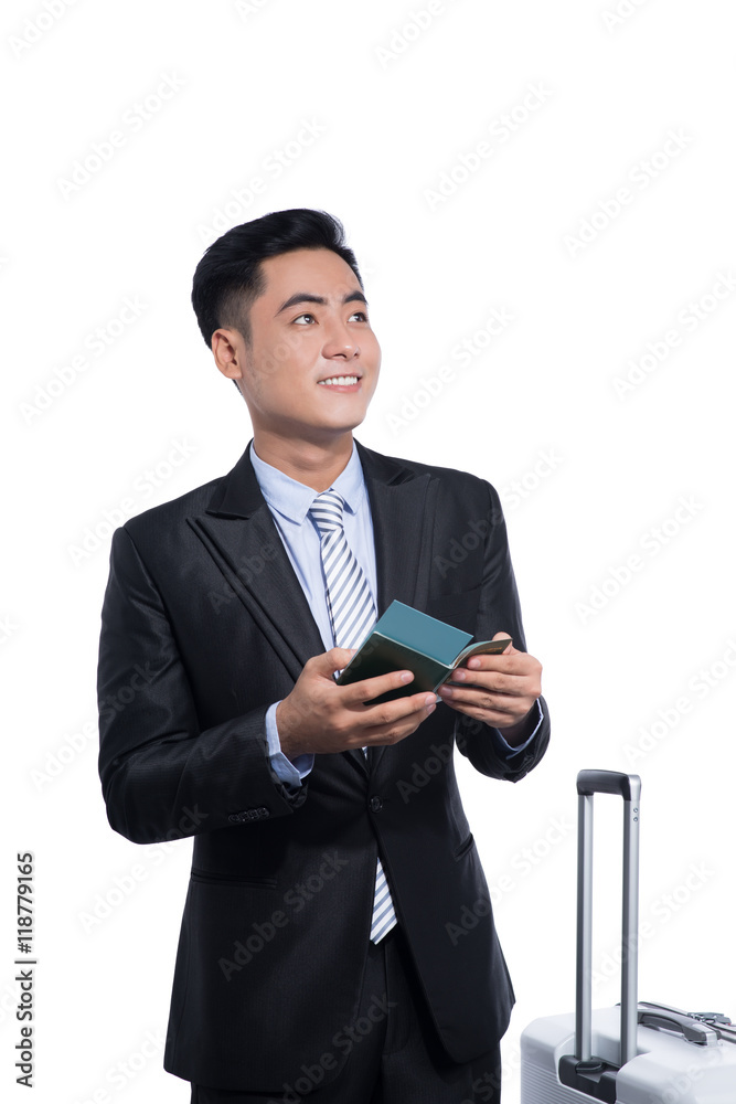 Asian business traveler pulling suitcase and holding passport an Asian business traveler pulling suitcase and holding passport an