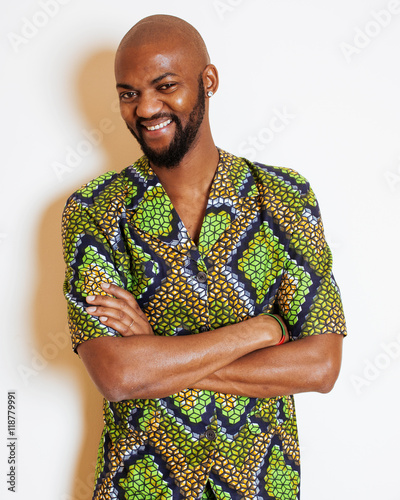 portrait of young handsome african man wearing bright green national costume smiling gesturing photo