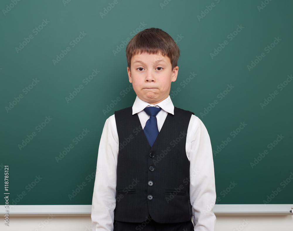 school student boy posing and think at the clean blackboard, grimacing and emotions, dressed in a black suit, education concept, studio photo school student boy posing and think at the clean blackboard, grimacing and emotions, dressed in a black suit, education concept, studio photo