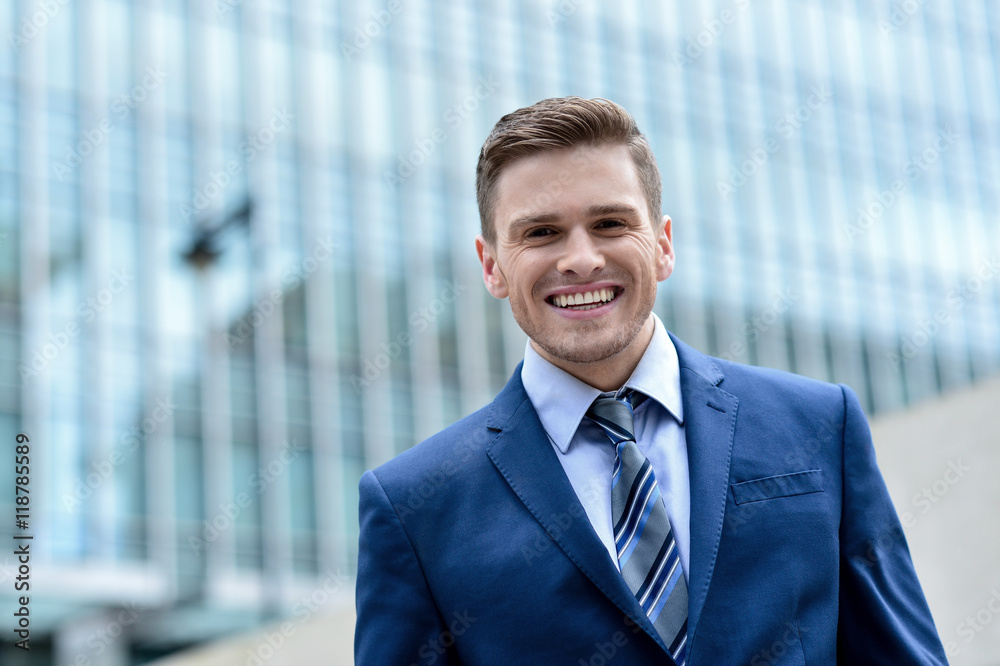 Attractive businessman posing in front of buildings