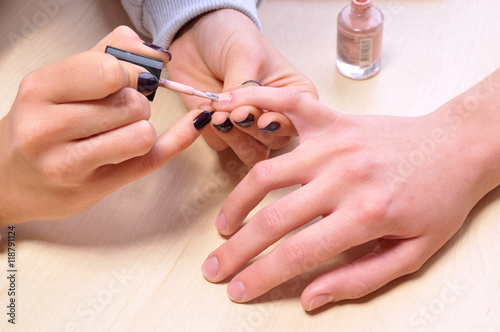 Closeup shot of woman in a nail salon. Receiving a manicure by a beautician.