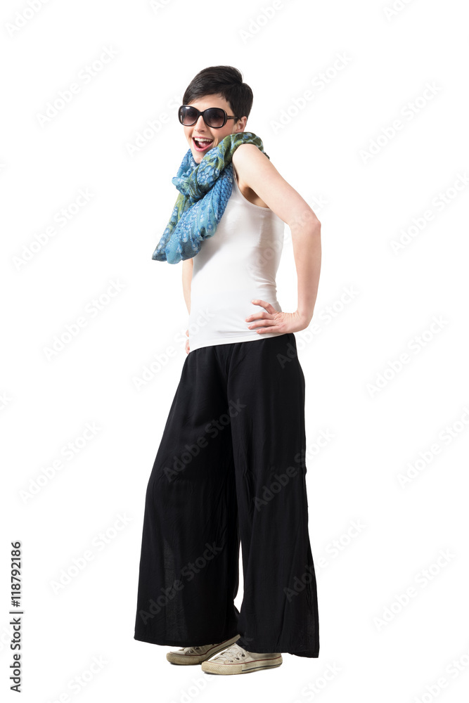 Laughing short hair girl wearing sunglasses with hands on hips pose ...