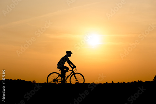 Silhouette of cycling on sunset background