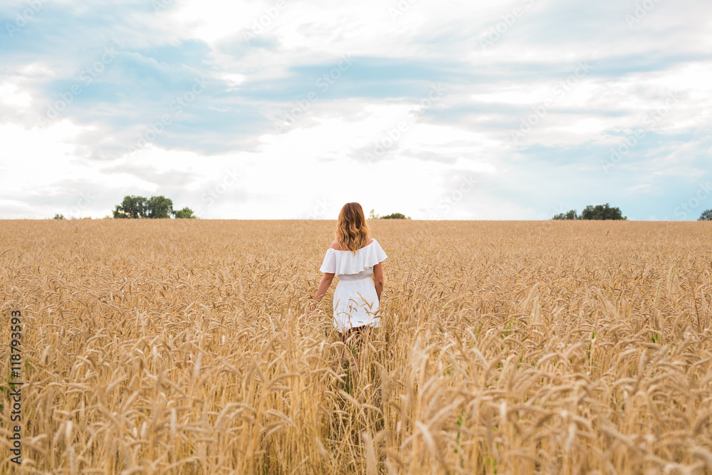 woman walking in the wheat- concept about nature, agriculture and people.