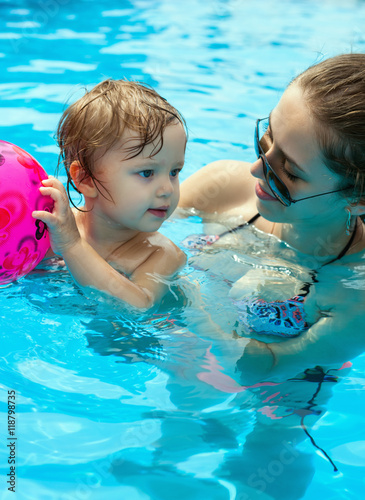 Young mother with her little daughter in the pool
